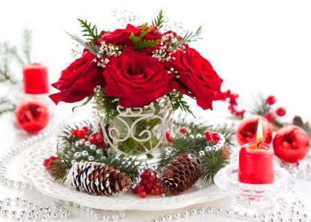 red roses and pincones in christmas arrangement